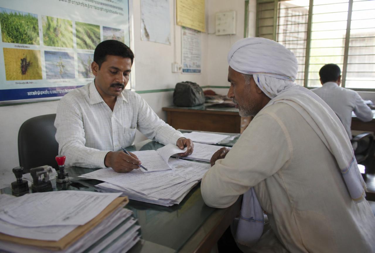 Farmer completing a subsidy application with an agricultural extension officer