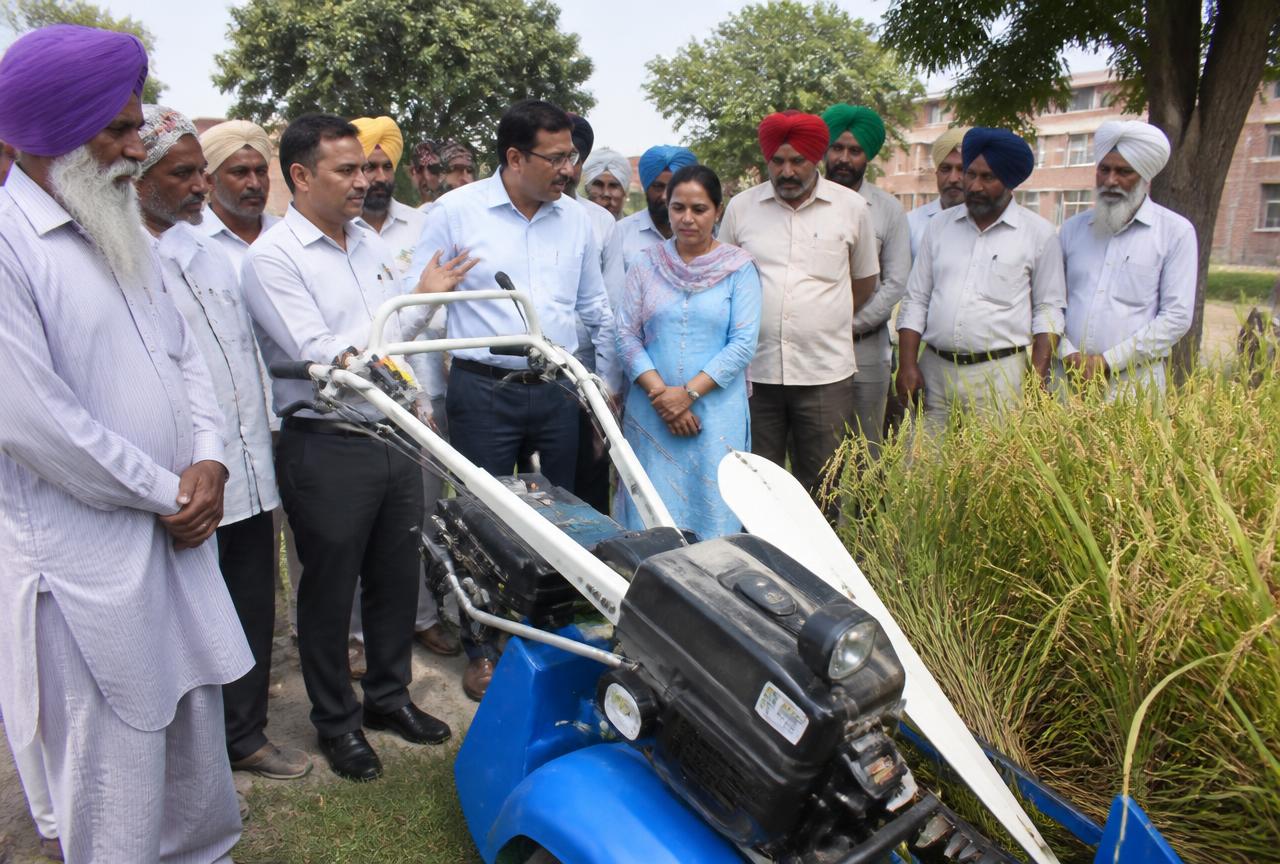 Agricultural university staff demonstrating machinery to farmers on campus